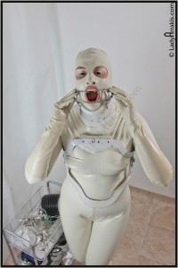 Sterile White  Jawspreader - If you are fan of medical moods and clinical accesoires, this clip is for you!
lady completely encased in white latex suit (catsuit, gloves, mask) and orthopedic harnesses - neck collar and backbone stabiliser slowly applies stainless steel jawspreader. She wears black lenses, what adds more oddity to the scene...
leans forward and saliva begans to flow...
bizarre, static video overflown with white and steel color palette and atmospheric music. 4 minutes, with music.