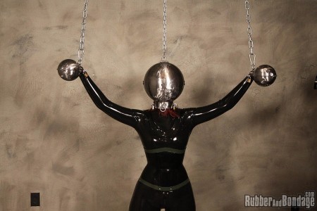 Head Bangers Ball - The combination of heavy metal and rubber really seems like an odd pairing on paper. In reality, metal is such an awesome raw material to utilize in the creation of any bondage device. I do not know what it is about this particular set of metal head and hand balls we had custom made for the rubber and bondage studio but they amplify my desire to do bad things to women. I don't know if it is about the dehumanizing nature it creates for the women trapped inside. Maybe it is just the overall *********** experience generated for the submissive women we pair the device with. It could be that I just like taking things away from women in as bizarre a manner as possible. In any case, miss k was the latest latex clad ****** to serve time locked inside these spheres. Once positioned properly, the balls were locked onto her head and hands. Chains were connected to each metal hand ball which ****** her arms up, out and wide. Another chain was affixed to the top of the head ball to support the weight of the metal. 

since miss k was going to be busy coping with sensory overload and deprivation at the same time, we figured she did not need to be trying to keep her head from flopping over or off. There is also the issue of the one tiny hole in the front of the head ball that allows for limited air in an out. This would serve to further increase miss k's heart rate and potential for panic. The more distressed the submissive the better in my opinion. Once miss k was strung up and ready to be rocked, our guest controller "fk" stepped in while fully clad in rubber, head to toe. He used to be in a band I am told so he strummed some notes on miss k's clit with real expertise. He uses a vibrating magic wand while trying to get her pussy in tune. Eventually fk started playing tease and denial which is one of our all-time favorites. Near the grand finale of our head bangers ball, miss k is ****** to cum, rocked and rolled into the orgasm hall of fame. For those about to get their clit rocked, we salute you.