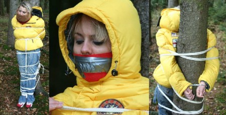 Assault In The Forest - Miri is still wearing a very heavy down jacket and the drama continues in the forest. Tied up to a tree with rope and handcuffs, still gagged, still helpless.